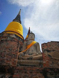 Low angle view of statue against temple building against sky