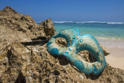 Close-up of rocks on beach against clear blue sky