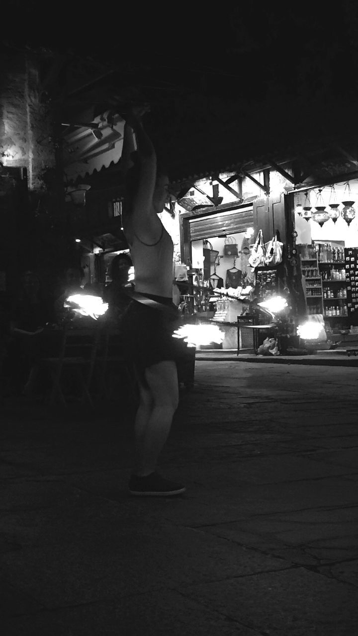 black, darkness, night, white, light, lifestyles, black and white, one person, illuminated, full length, architecture, adult, built structure, leisure activity, monochrome, city, standing, monochrome photography, men, women, street, dancing, building exterior