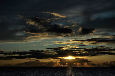 Scenic view of sea against dramatic sky during sunset