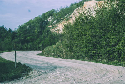 Road amidst trees against sky