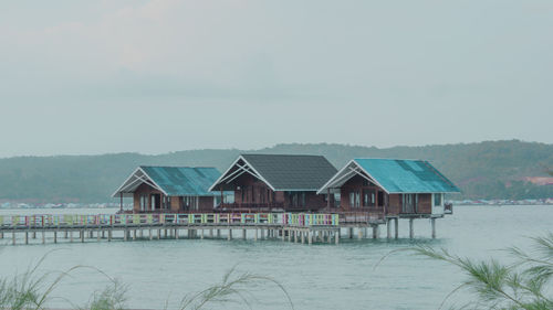 Houses by building against sky