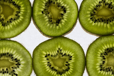 Full frame shot of kiwis against white background