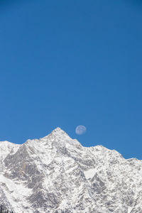 Scenic view of snowcapped mountains against clear blue sky