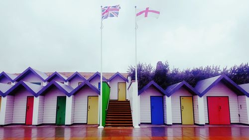 Beach huts against buildings against sky