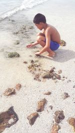 Full length of shirtless boy on beach