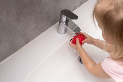 Caucasian child washing hands for protecting from covid