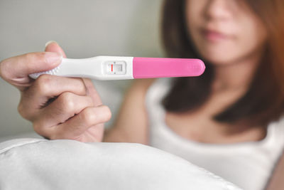 Close-up of woman holding pregnancy test equipment