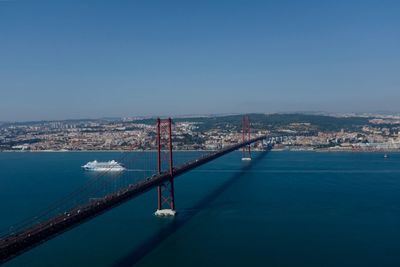 View of city by sea against clear blue sky