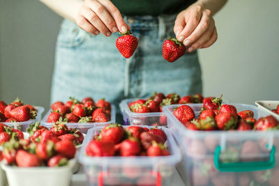 Cropped hand of woman holding strawberries