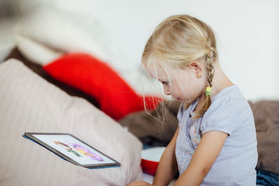 Girl using laptop on bed at home