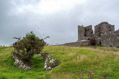 Old ruin building on field against sky