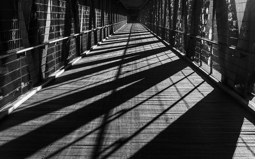 Shadow streaming through railing on bridge