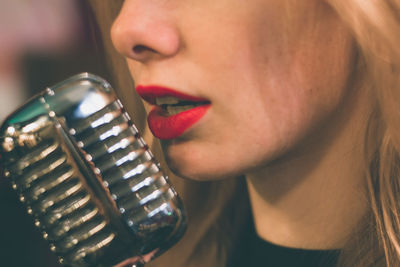 Close-up of young woman with vintage microphone