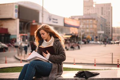 Young woman sitting in city