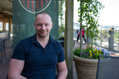 Portrait of smiling man sitting at sidewalk cafe