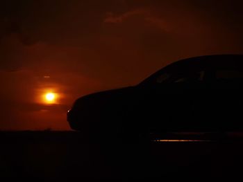 Silhouette of airplane against sky during sunset