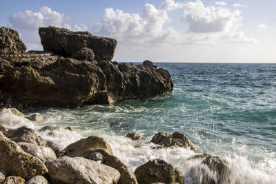 Scenic view of rocks in sea against sky