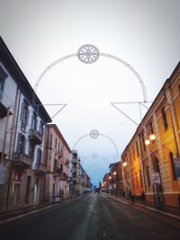 Road amidst buildings against sky
