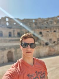 Portrait of young man wearing sunglasses standing outdoors