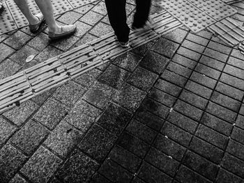 Low section of man standing on cobblestone