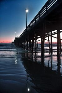 Pier on sea against sky during sunset