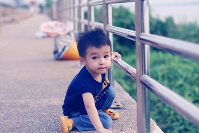 Portrait of cute boy sitting outdoors
