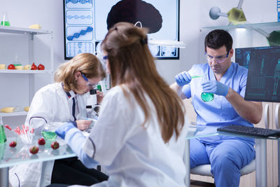 Side view of female doctor examining patient at home