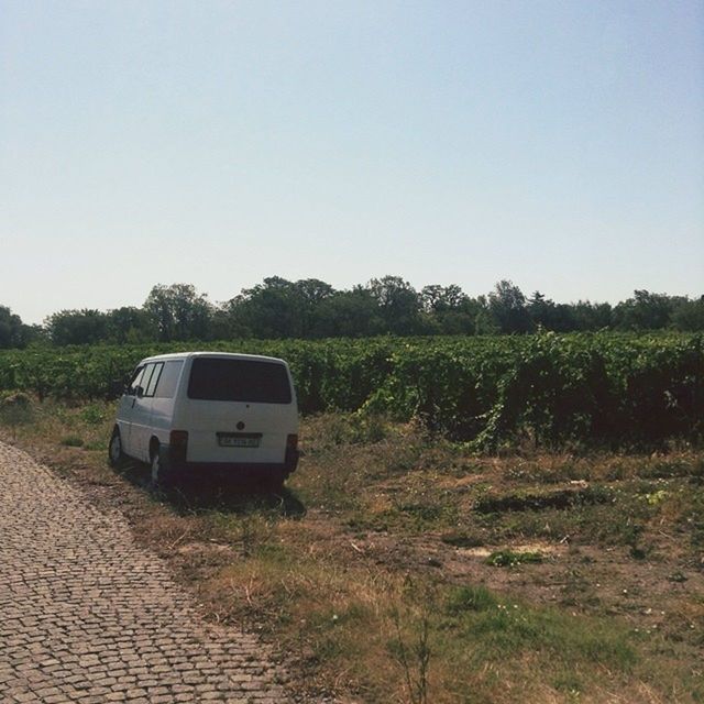 transportation, mode of transport, clear sky, land vehicle, car, copy space, tree, landscape, field, road, travel, nature, stationary, grass, day, tranquility, tranquil scene, outdoors, no people, sky