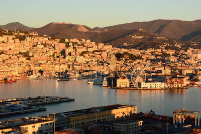 Aerial view of townscape by bay against sky