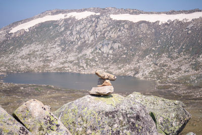 Scenic view of rock by lake against mountain