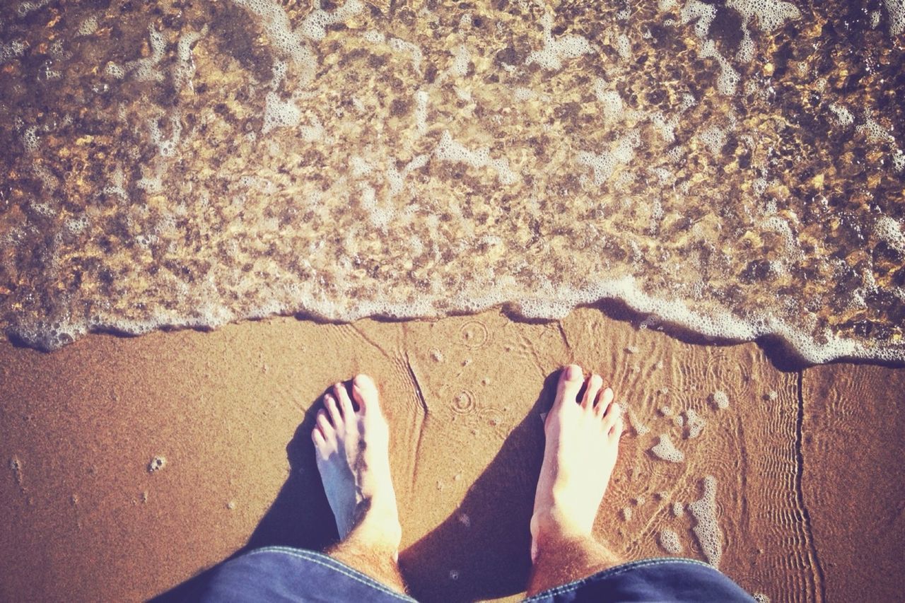 low section, person, beach, personal perspective, sand, barefoot, human foot, water, shore, lifestyles, leisure activity, sea, standing, high angle view, vacations, relaxation