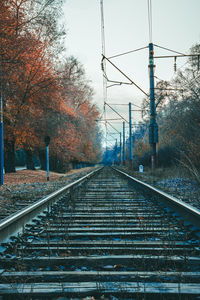 Railroad tracks by trees against sky