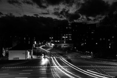 Light trails on road against sky at night