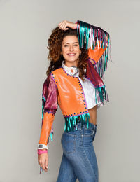 Portrait of smiling young woman standing against white background