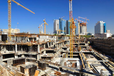 Aerial view of construction site against buildings in city