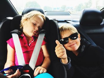 Portrait of boy wearing sunglasses with sister in car