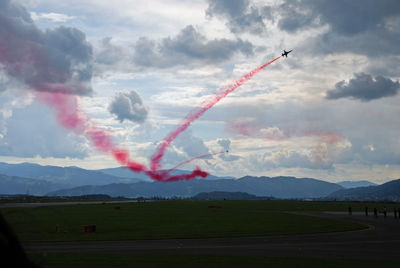 Airplane flying over landscape against sky