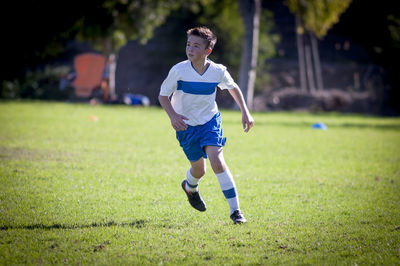 Teen soccer player running on a soccer field