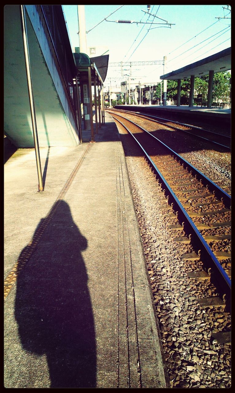 railroad track, transfer print, shadow, transportation, sunlight, the way forward, auto post production filter, railroad station platform, rail transportation, railing, built structure, railroad station, diminishing perspective, connection, high angle view, architecture, day, metal, vanishing point, empty