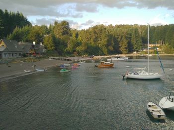 Boats moored in water against sky