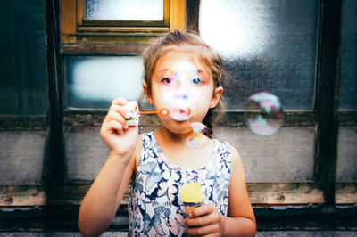 Portrait of girl holding bubbles