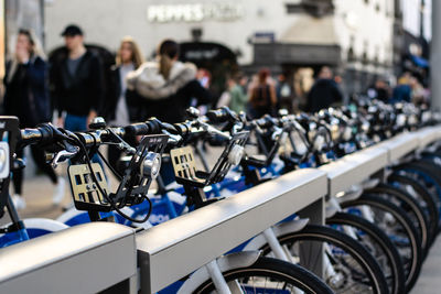 Close-up of bicycles parked on footpath in city