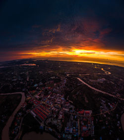 Aerial view of illuminated cityscape against sky during sunset