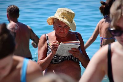 Rear view of people sitting in sea