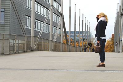 Full length of woman standing on bridge in city