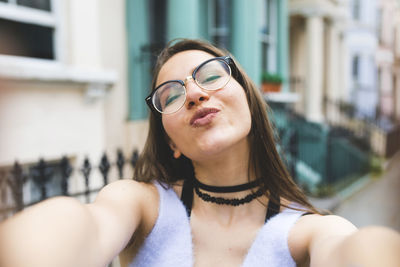 Happy teenage girl in the city taking a selfie