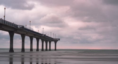 Pier over sea against sky during sunset