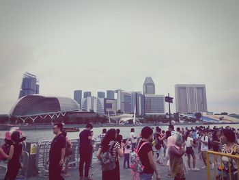 Group of people in city against sky