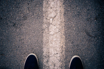 Low section of person standing on road